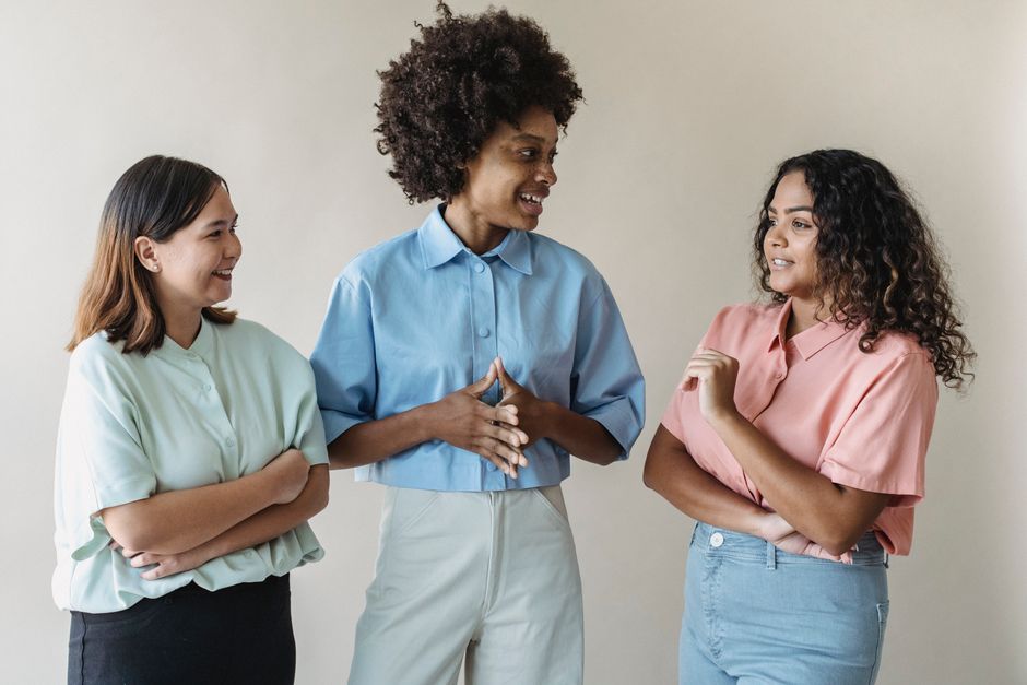 A diverse group of people communicating using American Sign Language in a bright, welcoming community center setting