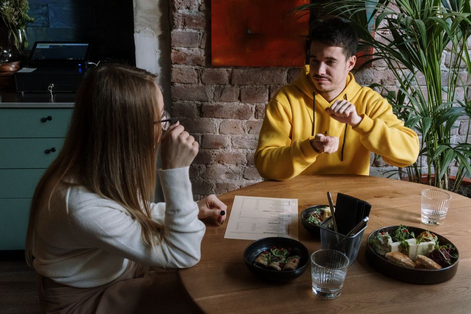 A group of Deaf individuals communicating in German Sign Language (DGS) in a community center